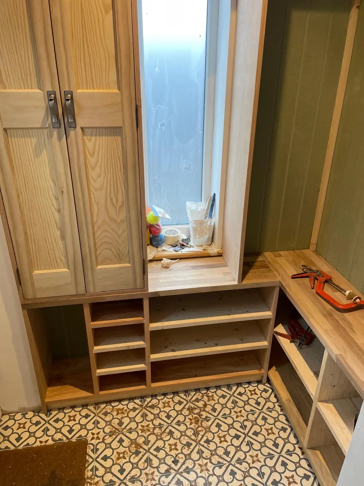 Fitted boot room cabinetry with oak shaker cupboards, bench and shoe shelving