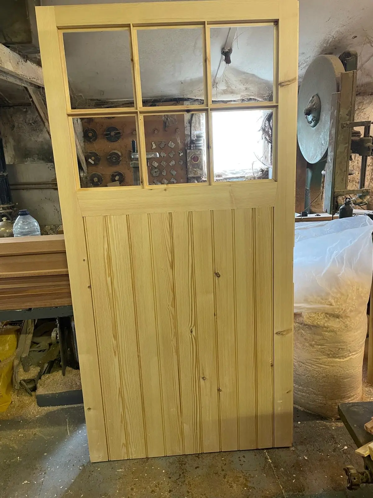 New timber cottage door with six glazed panes and tongue-and-groove panelling in the workshop