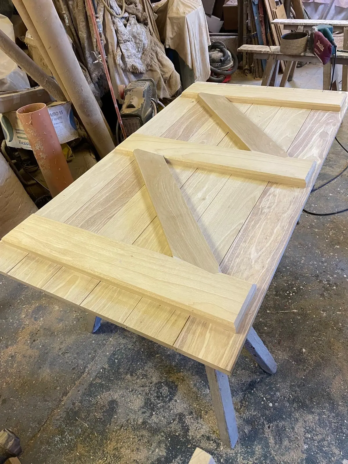 Oak ledged-and-braced door under construction on a workshop trestle, showing the bracing detail